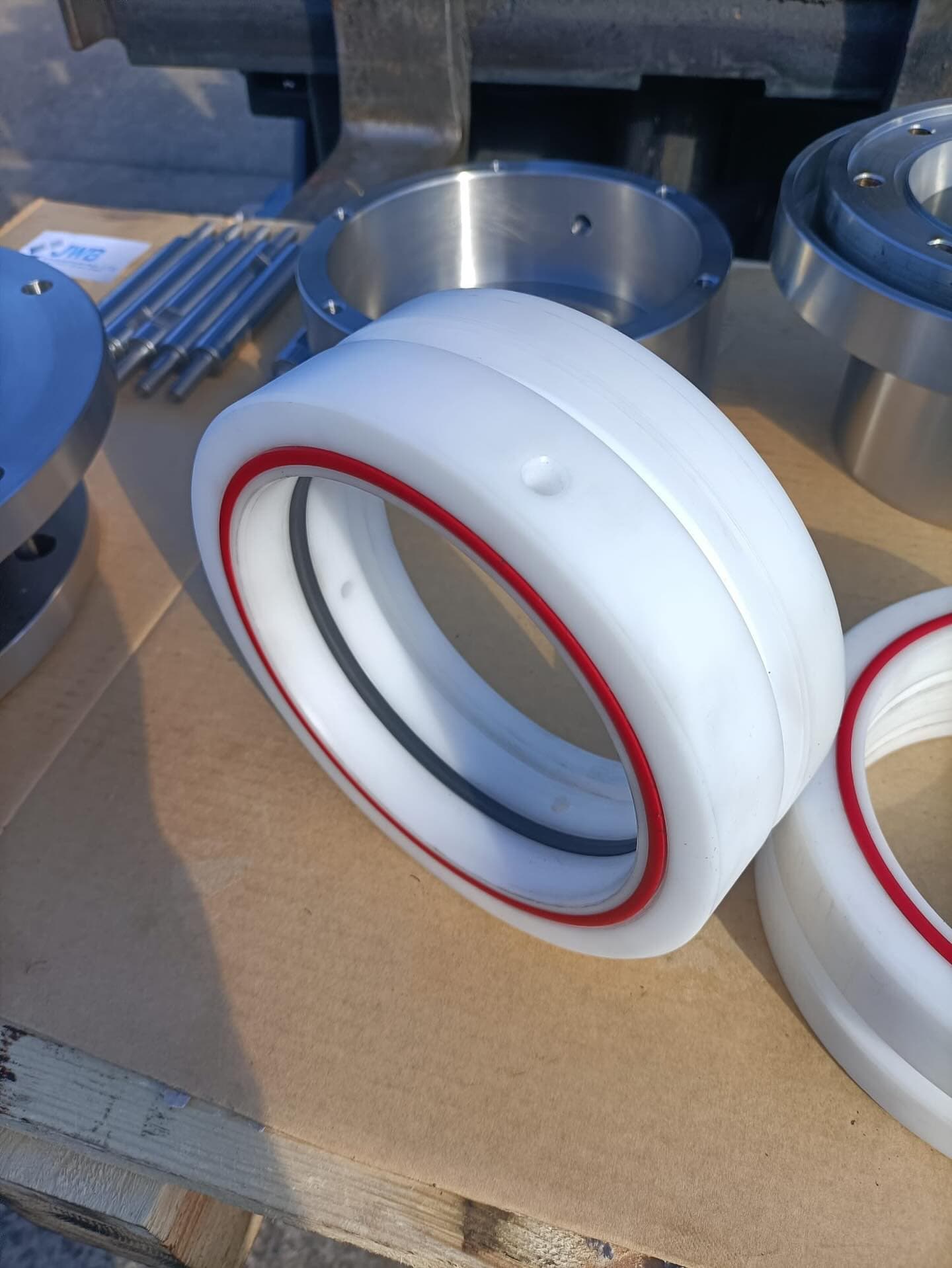 Machined nylon seal carriers with new seals fitted beside steel flanges in the JWB Engineering workshop