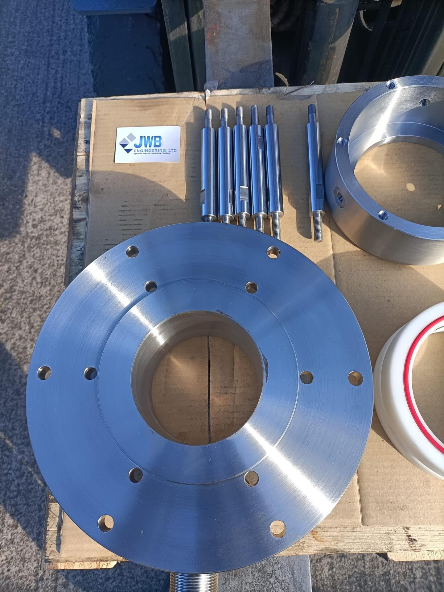 Precision machined steel flange with bolt hole pattern and matching turned studs