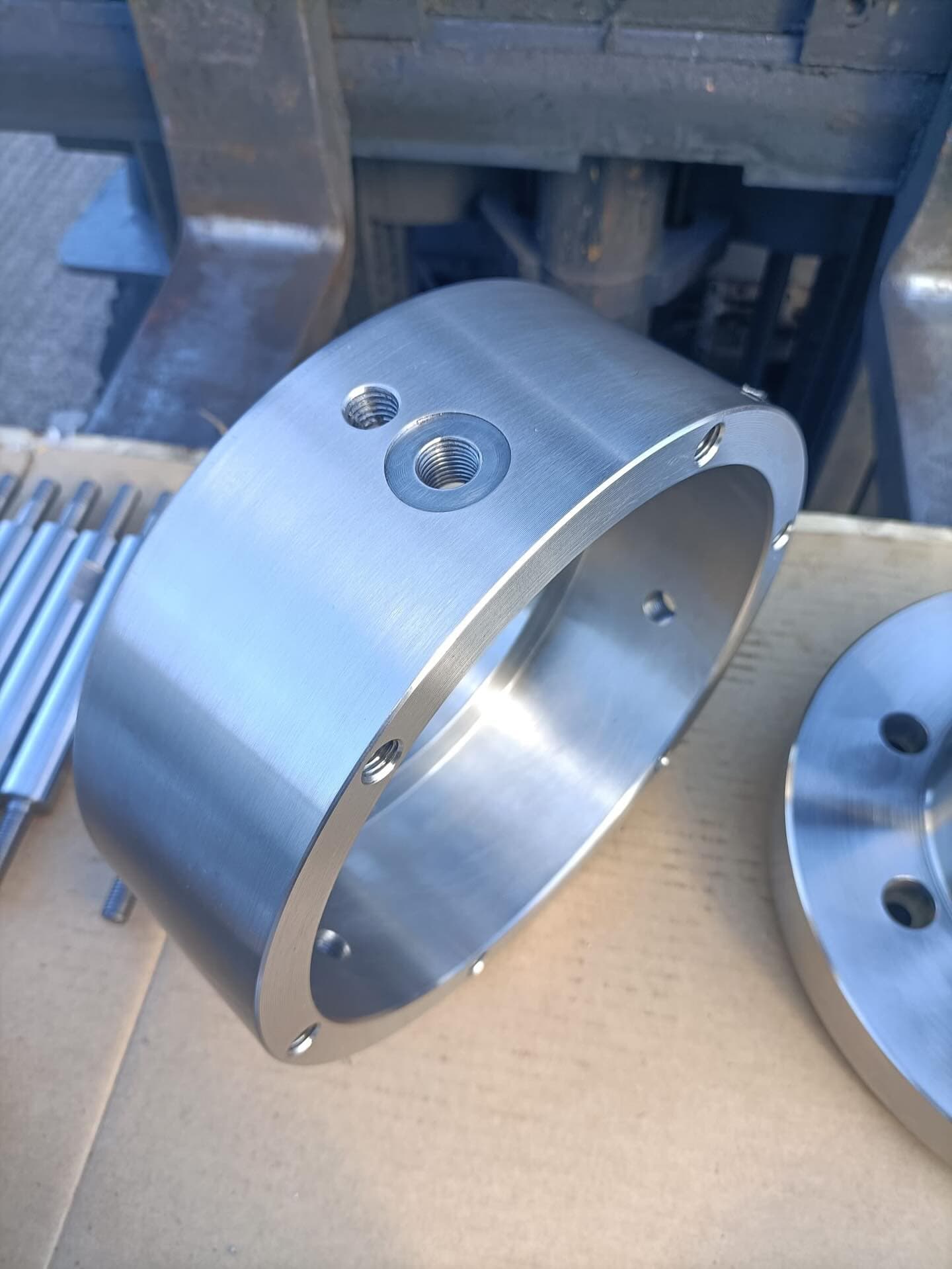 Machined stainless steel bearing housing with tapped ports and bolt holes
